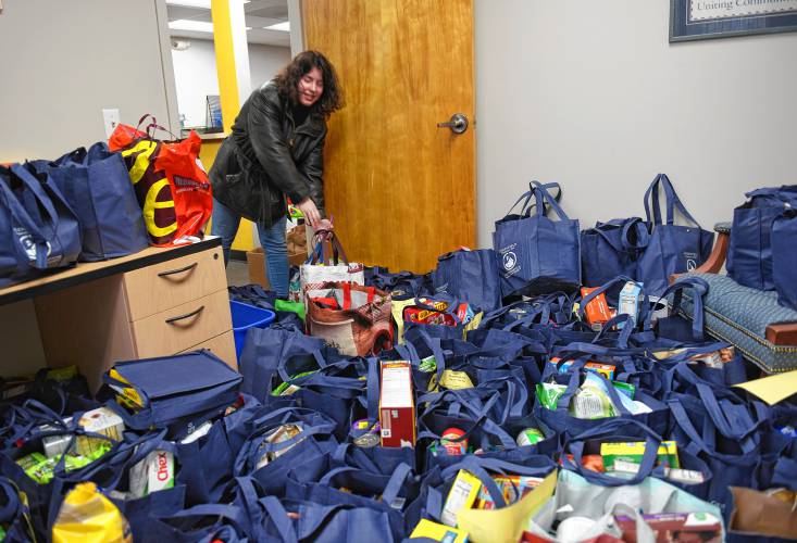 Employee Elsa Kieffer piles donations for the 20th annual Supper for Six food drive into the United Way of the Franklin & Hampshire Region’s Davis Street offices in Greenfield on Thursday.