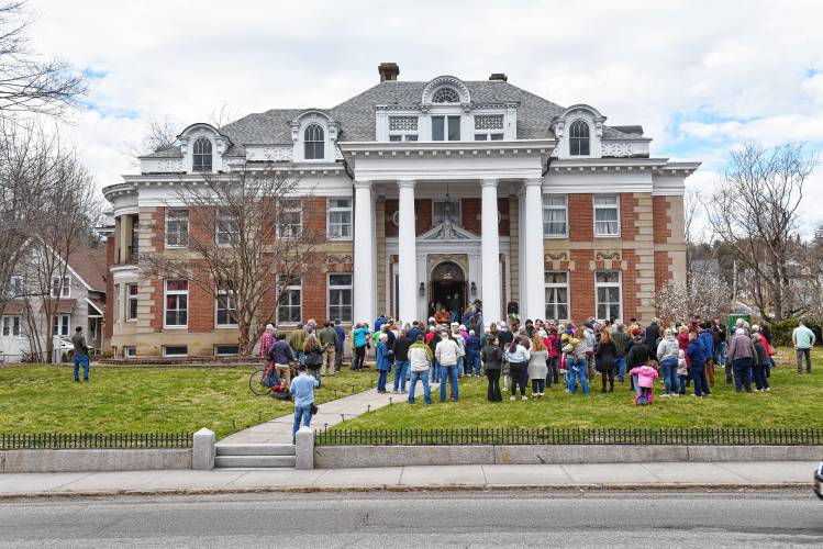 People gather on the front lawn to toast the ribbon cutting of the renovated Revival Wheeler Mansion in Orange on Monday.