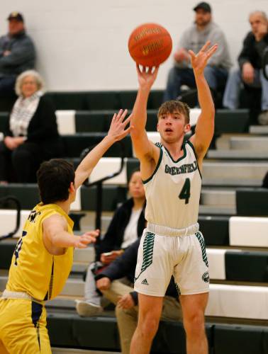 Greenfield’s Caleb Murray (4), right, puts up a shot over Hopkins Academy’s Alex West last season in Greenfield.