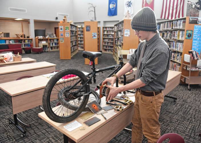 Ralph C. Mahar Regional School student Maximus Parsons shows where he will mount the electric motor onto a BMX bike conversion at the Mahar Makers’ Makerfaire on Wednesday.