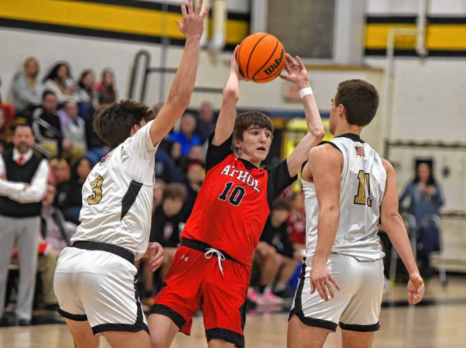 Athol’s Ben Kearney (1) tries to make a pass while defended by Pioneer’s Kurt Redeker (3) and Hugh Cyhowski (11) during the host Panthers’ 42-32 victory in the MIAA Division 5 Round of 16 on Tuesday night at Messer Gymnasium in Northfield.