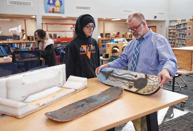 Ralph C. Mahar Regional School student Elias Roberts shows Principal Scott Hemlin his seven-layer laminated skateboard and the form he used to make it at the Mahar Makers’ Makerfaire on Wednesday.
