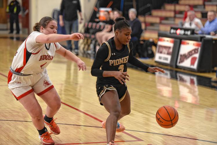 Pioneer’s Fota N’Diaye, right, dribbles in front of Hoosac Valley’s Maryn Cappiello (4) during the Panthers’ 57-35 loss in the Western Mass. Class D championship game on Saturday at Westfield High School.