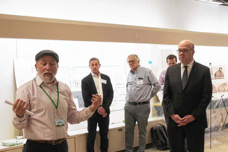 John Williams, general manager of Green Fields Market, left, details the Franklin Community Co-op’s plans to move into the former Wilson’s Department store’s space by 2026 as U.S. Rep. Jim McGovern, far right, looks on.