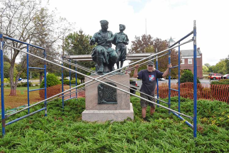 Jeffrey Bronnes, owner of Royalston Arts Foundry, sets up scaffolding around the Massachusetts Peace Statue in Memorial Park in Orange.