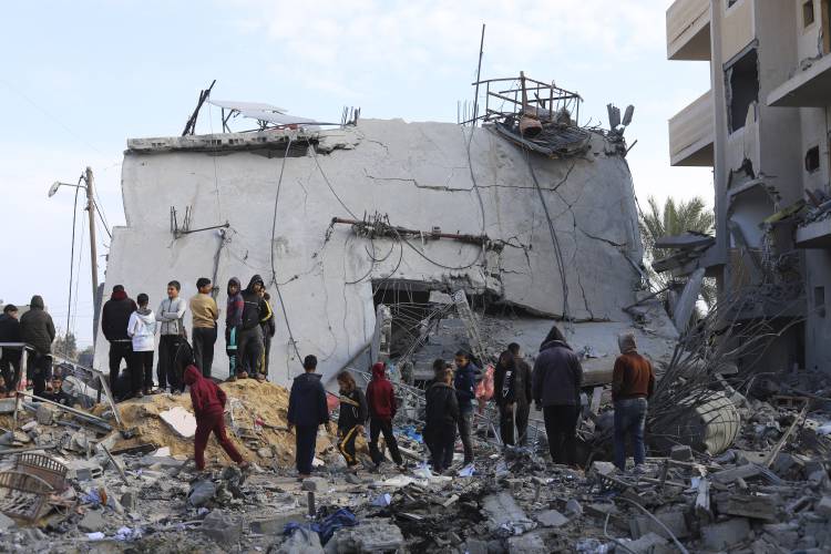 Palestinians look at the destruction after an Israeli strike on a residential building in Rafah, Gaza Strip, Friday, Feb. 16, 2024.