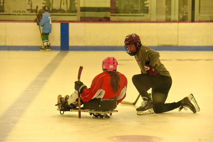 Owen Murray of the UMass hockey team provides guidance during CHD's All In Sled Hockey Open Skate on Monday at the Mullins Center practice rink in Amherst.