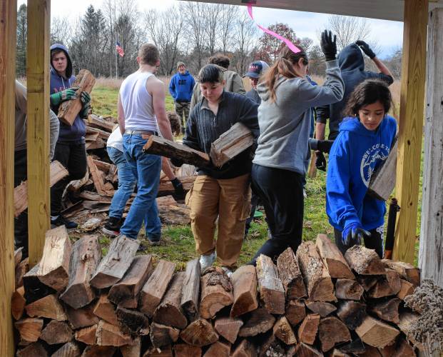 Mahar wrestlers stacking wood to fundraise for their team.