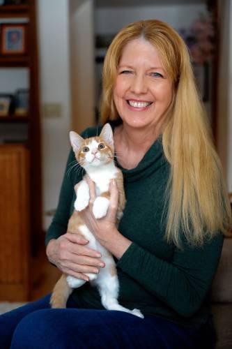Rehome with Love founder and owner of Joyful Pets Rescue Lauren McCarron holds Sunny, one of the cats in her care looking to be rehomed, at her home in Wendell.