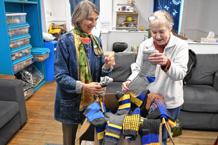 Lina Bernstein, left, is assisting her sister-in-law Katherine Erwin, of Orange, to deliver socks to Ukrainian soldiers through RememberUs.org. Erwin and other knitters of the Dragonfly Sock Knitters created the socks and small key chains in their Orange storefront studio.