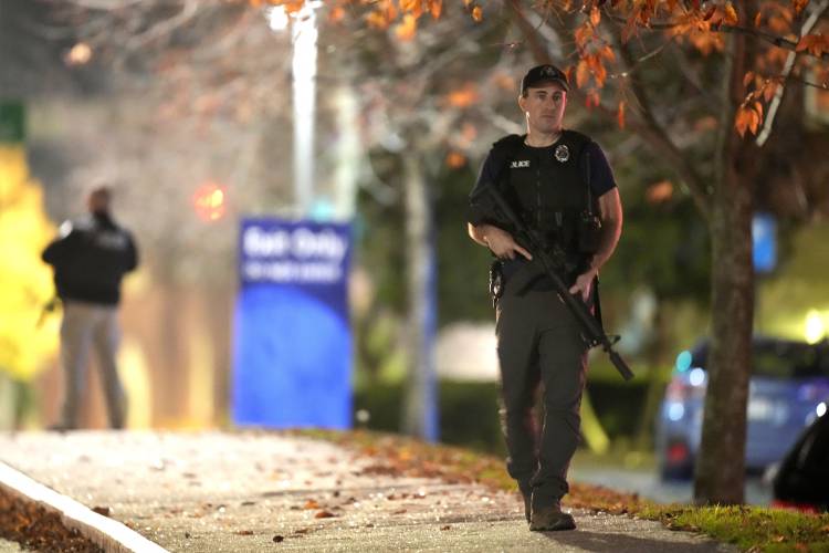 Law enforcement officers carry rifles outside Central Maine Medical Center during an active shooter situation, in Lewiston, Maine, Wednesday, Oct. 25, 2023. (AP Photo/Steven Senne)