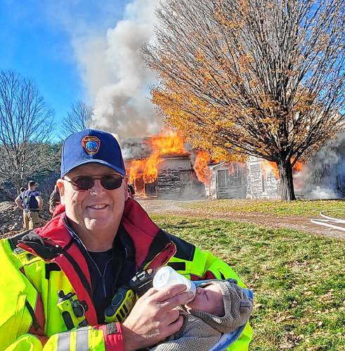 Bob Manners, longtime Shelburne Fire Department chief, and his grandson, Otto, in October 2022 during a controlled burn at a structure donated by neighbors Carolyn and John Wheeler so future firefighters could train for certification.