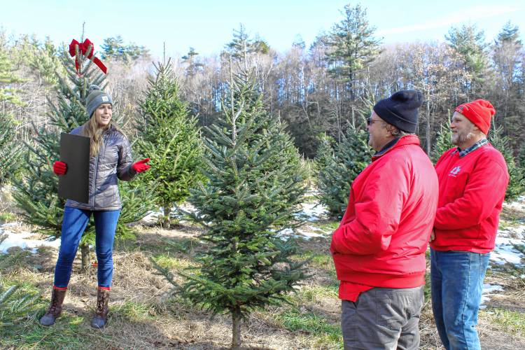 Massachusetts Department of Agricultural Resources Commissioner Ashley Randle speaks to Cranston’s Tree Farm owners and brothers Seth and Jonathan Cranston on Friday.