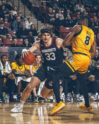 UMass forward Matt Cross (33) drives baseline on VCU’s Michael Belle in the first half of the Minutemen’s game against the Rams on Tuesday night at the Mullins Center.