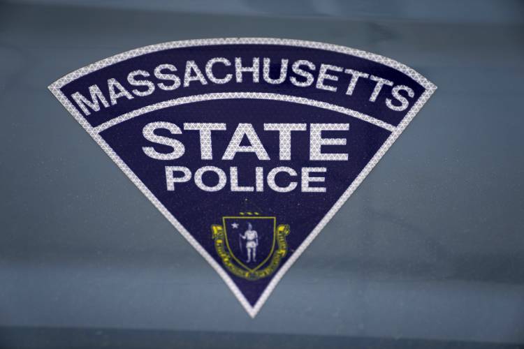 The seal of the commonwealth of Massachusetts is displayed on a Massachusetts State Police cruiser parked outside the State House in Boston.
