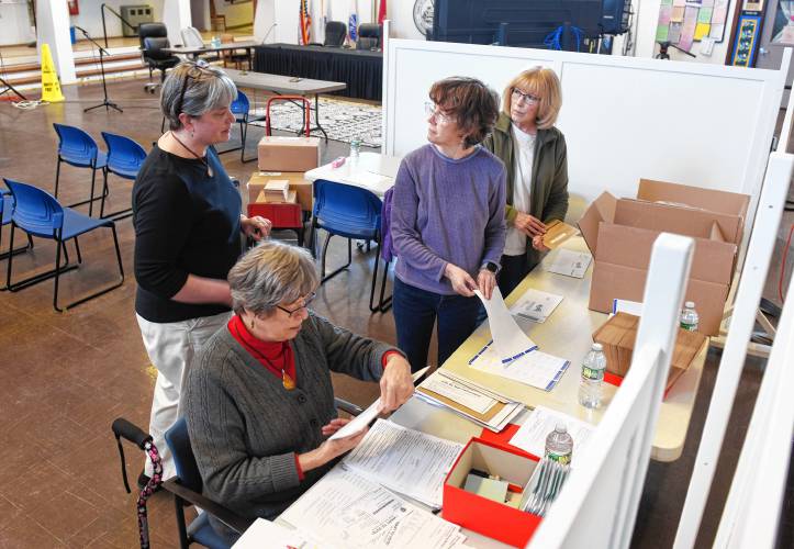 Deerfield Town Clerk Cassie Sanderell, left, talks with members of the League of Women Voters as Marge Michalski, Denise Petrin and Ruth Odom help process vote-by-mail applications in the Deerfield Town Hall on Monday.