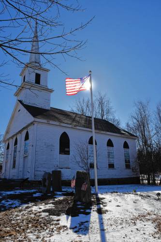 A flag that once flew of the U.S. Capitol flies over Veterans Park next to the 1794 Meeting House in New Salem.