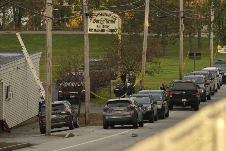Law enforcement gather outside Schemengee's Bar and Grille, Thursday, Oct. 26, 2023, in Lewiston, Maine. Residents have been ordered to shelter in place as police continue to search for the suspect of Wednesday's mass shooting at the bar. (AP Photo/Robert F. Bukaty)