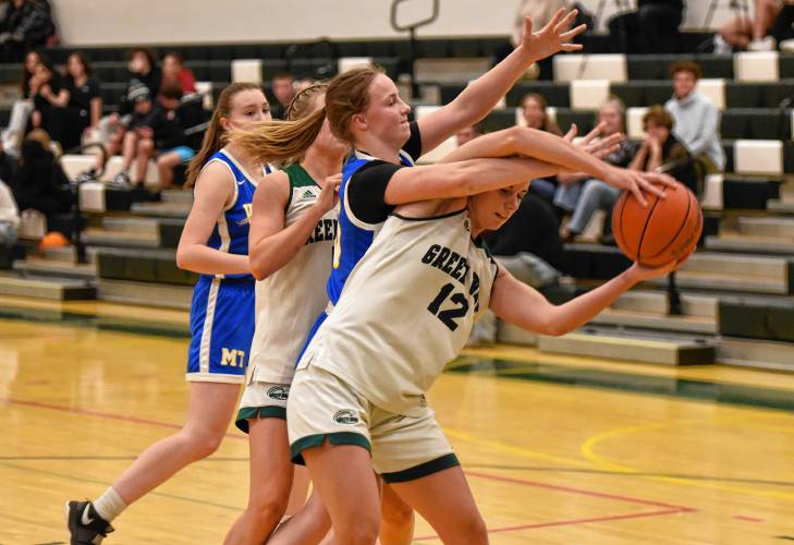 Greenfield’s Amber Bergeron (12) tries to hold onto possession of the ball while defended by Mohawk Trail’s Rachel Pease during action Tuesday night at Nichols Gymnasium in Greenfield.