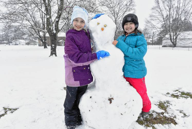 Self-proclaimed best friends Riya Clark, 9, and Brooklyn Simon, 9, build a snowman near their home in Turners Falls on Thursday afternoon.