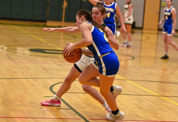 Mohawk Trail’s Valerie Bzomowski dribbles while defended by Greenfield’s Anna Bucala during action Tuesday night at Nichols Gymnasium in Greenfield.