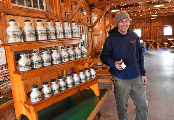 Chip Williams of Williams Farm Sugarhouse in Deerfield next to some maple syrup for sale.