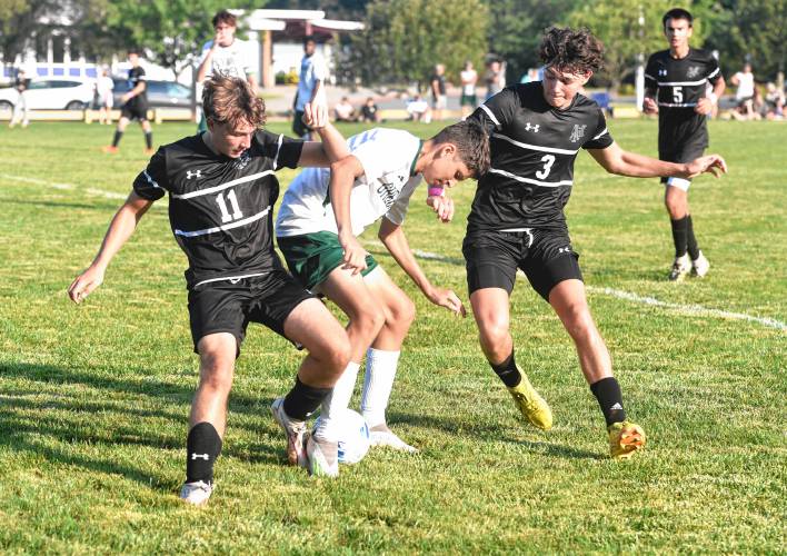 Pioneer’s Gavin Gammell (11), left, and Kurt Redeker (3) try and steal the ball away from Greenfield’s Lucian Volosenco (8) during the first half of action in Northfield on Wednesday.