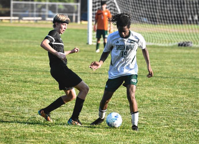 Greenfield’s Heskey Samu (19) looks to hold possesion while defended by Pioneer’s Judah Glenn (1) during the first half of action in Northfield on Wednesday.
