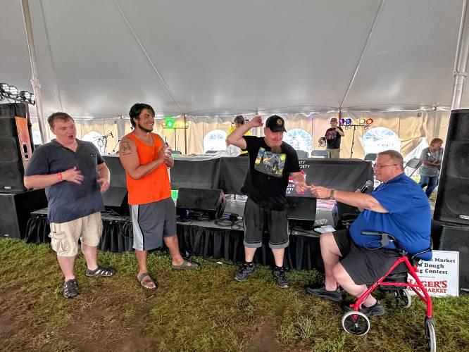 Robert “Bobby C” Campbell commends winners of the 2023 Franklin County Fair’s annual fried dough eating contest. From left: third-place winner David Eddy, second-place winner Maxwell Wilby and first-place winner Ken Bacigalupo.