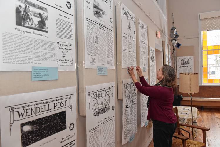 Friends of the Wendell Meetinghouse board member Debbie Lynangale labels enlarged copies of the Wendell Post that are on display at the Wendell Meetinghouse.