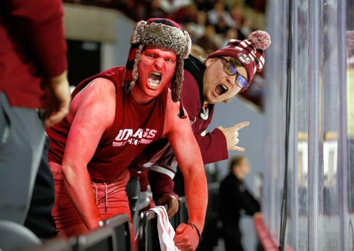 UMass fans Jimmy Whelan, left, and Noah Glickman cheer during the third period against Boston College on Friday night at the Mullins Center.