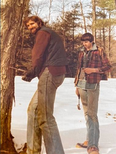 This vintage photo shows Milt Severance tapping a maple tree for sap, something he's been doing nearly all his life. A young friend looks on. Severance's Northfield sugarhouse will be the site of Maple Month kick-off activities this Friday morning.