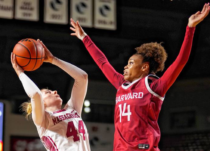 UMass’ Stefanie Kulesza (44), left, tries to get a shot up over Harvard’s Harmoni Turner (14) during non-conference action at the Mullins Center in Amherst on Thursday night.