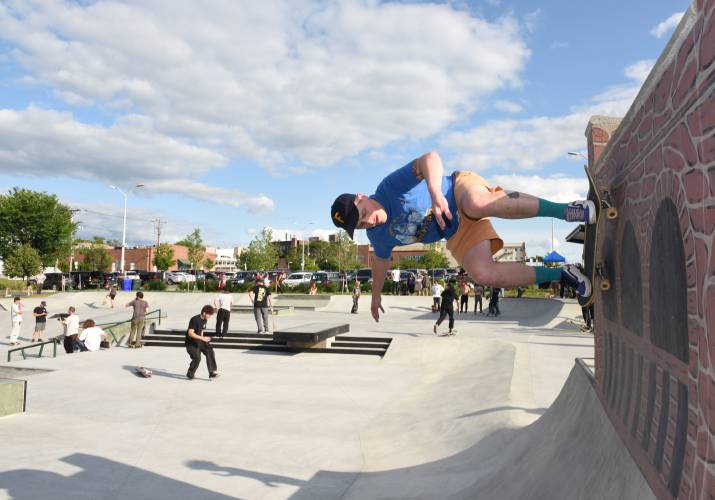A skater heads up and down the vertical wall at the grand opening of the Greenfield Skate Park in June.