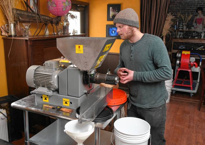 Jesse Marksohn prepares an oil press he is using to cold press hickory nuts into oil.