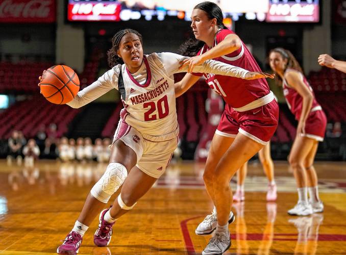 UMass’ Bre Bellamy (20) drives to the basket defended by Harvard’s Katie Krupa (31) duirng non-conference action at the Mullins Center in Amherst on Thursday night.