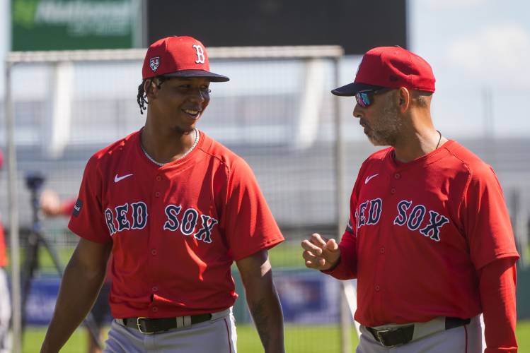Red Sox pitcher Brayan Bello, left, talks with manager Alex Cora during spring training in Fort Myers, Fla., Thursday, Feb. 15, 2024. (AP Photo/Gerald Herbert)