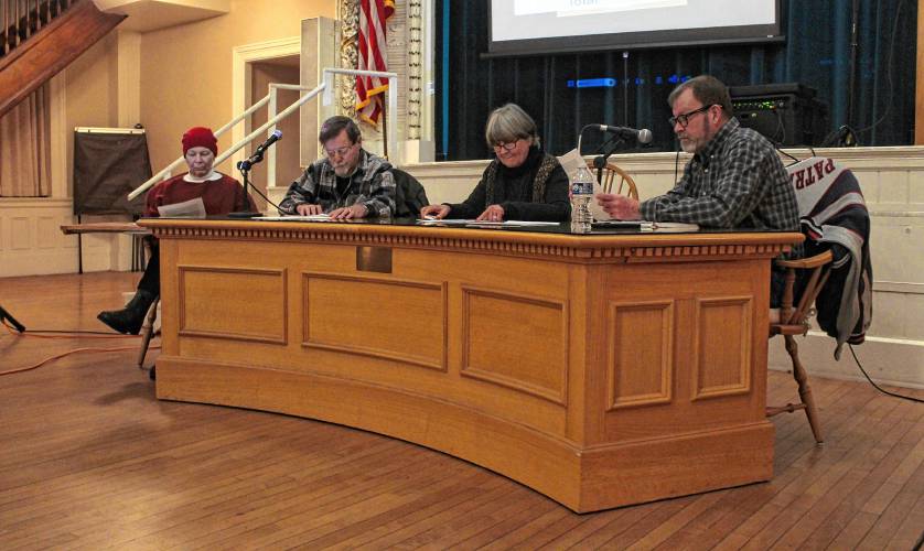 From left, Orange Selectboard member Jane Peirce, member Richard Sheridan, Clerk Pat Lussier and Vice Chair Andrew Smith sit at the front of the Ruth B. Smith Auditorium in Orange Town Hall during a Special Town Meeting on Thursday.