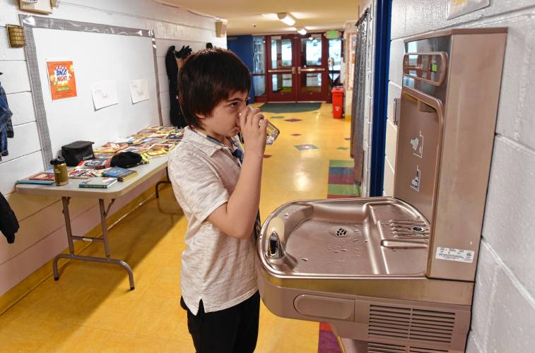 Fourth grade student Raymond Libby IV drinks a glass of water from the drinking fountain at Swift River School in New Salem.