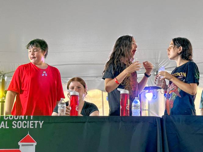 Third-place winner Jacobee McGivern, second-place winner Braeden Hydefrost and first-place winner Taimoor Dahlstrom-Hakki celebrate their victories in the kids’ division of the 2023 Franklin County Fair’s fried dough eating contest.