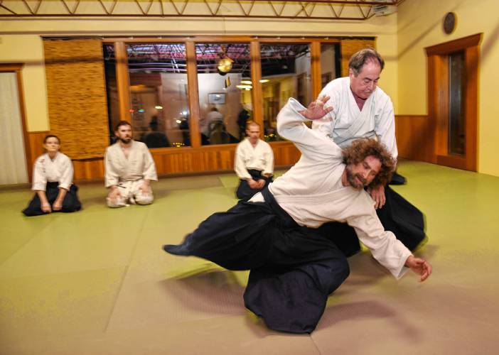 Dave Stier, co-owner of Green River Aikido in Greenfield throws student Joshua Wachtel, of Cummington, during a class last week.