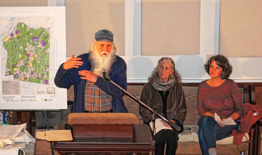 Bill Stubblefield speaks at a meeting of the “No Assaultin’ Battery Citizens Committee,” a non-governmental entity in opposition to the 105-megawatt battery storage facility proposed for the center of Wendell. In the background are committee member Anna Gyorgy and Molly Doody, chair of the Wendell Planning Board.