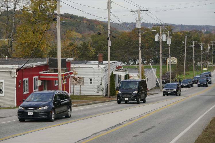 Three vehicles transport bodies from Schemengees Bar and Grille, Thursday, Oct. 26, 2023, in Lewiston, Maine. The restaurant was the site of one of the two mass shootings in Lewiston on Wednesday. (AP Photo/Robert F. Bukaty)