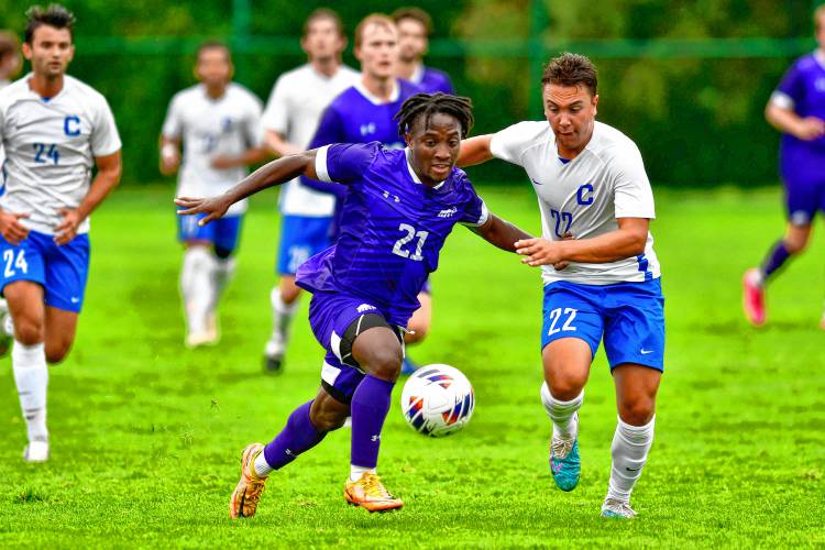 Amherst College’s Mohammed Nuhu (21), left, battles for possession earlier this season against Connecticut College. 