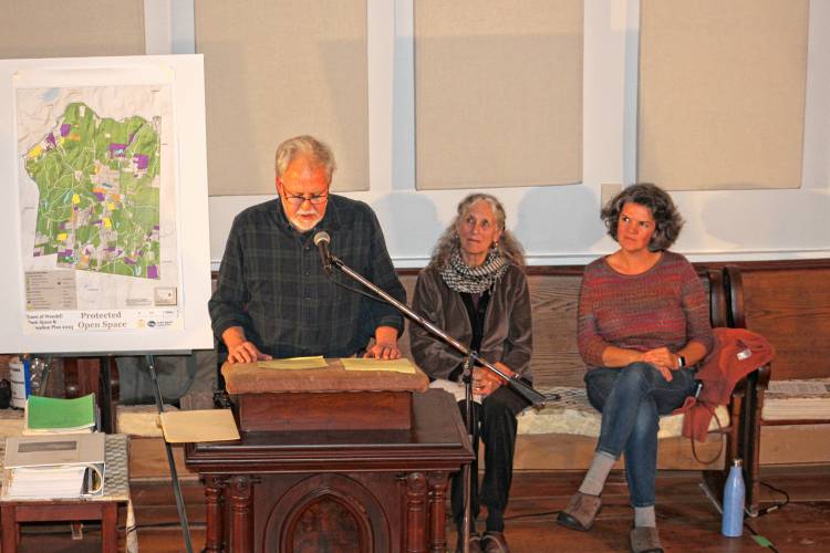 Dan Leahy, chair of the Wendell Open Space Committee, speaks at a meeting of the “No Assaultin’ Battery Citizens Committee,” a non-governmental entity in opposition to the 105-megawatt battery storage facility proposed for the center of Wendell. In the background are committee member Anna Gyorgy and Molly Doody, chair of the Wendell Planning Board.