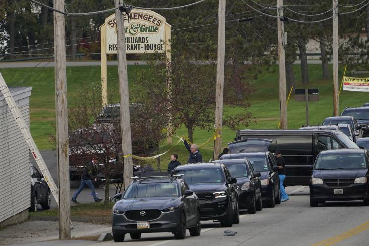 A body is wheeled out on a stretcher at Schemengees Bar and Grille, Thursday, Oct. 26, 2023, in Lewiston, Maine. The restaurant was the site of one of the two mass shootings in Lewiston on Wednesday. (AP Photo/Robert F. Bukaty)