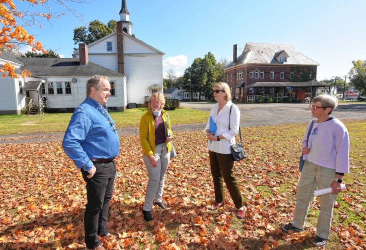 From left, Deerfield Selectboard member Tim Hilchey, Massachusetts Climate Chief Melissa Hoffer, Deerfield Planning Board Chair Denise Mason and M.A. Swedlund of the Deerfield Energy Committee talk about the future of the town’s municipal campus that would involve a senior center in the church and town offices in the old senior center pictured at right behind them.