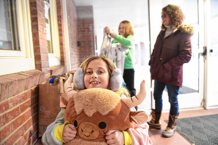 Phoenix Haffner, 9, with a new stuffed animal that was among donations at Buckland-Shelburne Elementary School collected for her family who lost everything in a fire on Saturday.