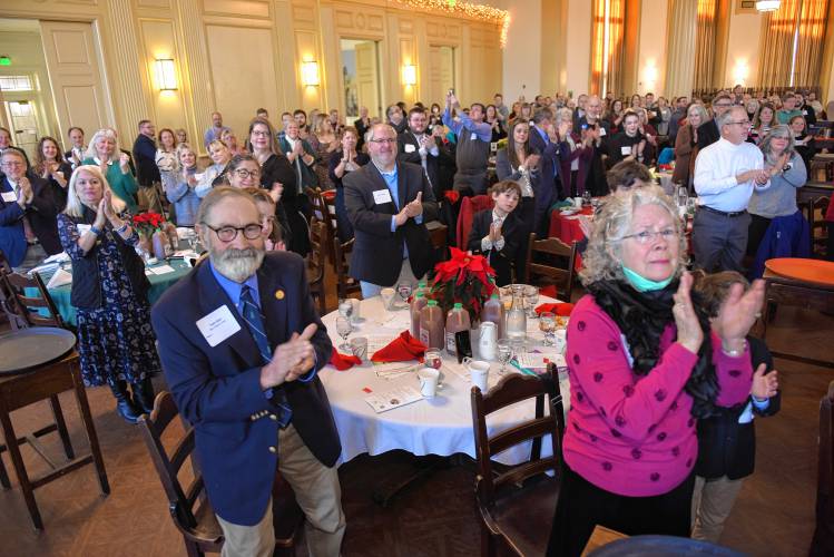A standing ovation for Greenfield Recorder Citizen of the Year Ben Clark from his family table at the Franklin County Chamber of Commerce’s holiday breakfast at Deerfield Academy on Tuesday morning.