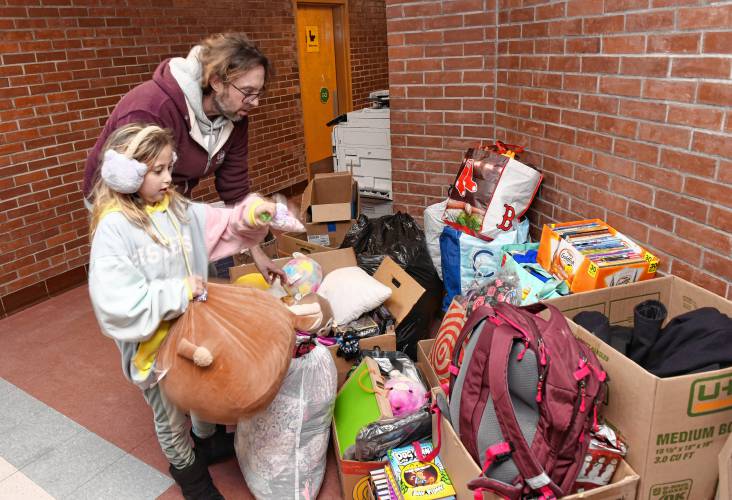 Grant Haffner and his daughter Phoenix, 9, look through donated items at Buckland-Shelburne Elementary School on Wednesday. The family lost their home in a fire on Saturday and has since received an outpouring of community support.